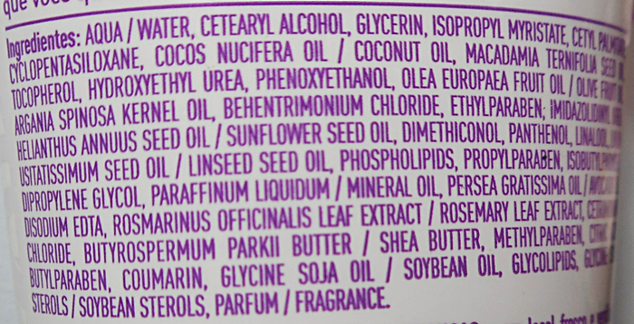 Detalhe dos ingredientes em uma garrafa de loção corporal, evidenciando a formulação e os componentes.